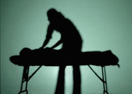 Silhouette of a person receiving massage therapy, symbolizing relaxation and therapeutic touch for wellness.