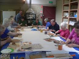 Group of individuals engaged in a Painting with Parkinson's art therapy session, showcasing diverse participants focused on creating artwork, highlighting the therapeutic benefits of art for those with Parkinson's disease.